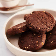 Unwrapped Byron Bay Cookies Triple Choc Gluten Free Cookies stacked on plain white plate.