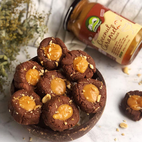 Nature's Charm Coconut Caramel Sauce packaged in glass jar and shown served on top of chocolate cookies.