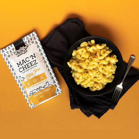 Plantasy Foods Mac 'N Cheez Plant-based pasta meal in stand up pouch. Original cheez flavour pasta finished product in black bowl with fork, pictured next to product package.